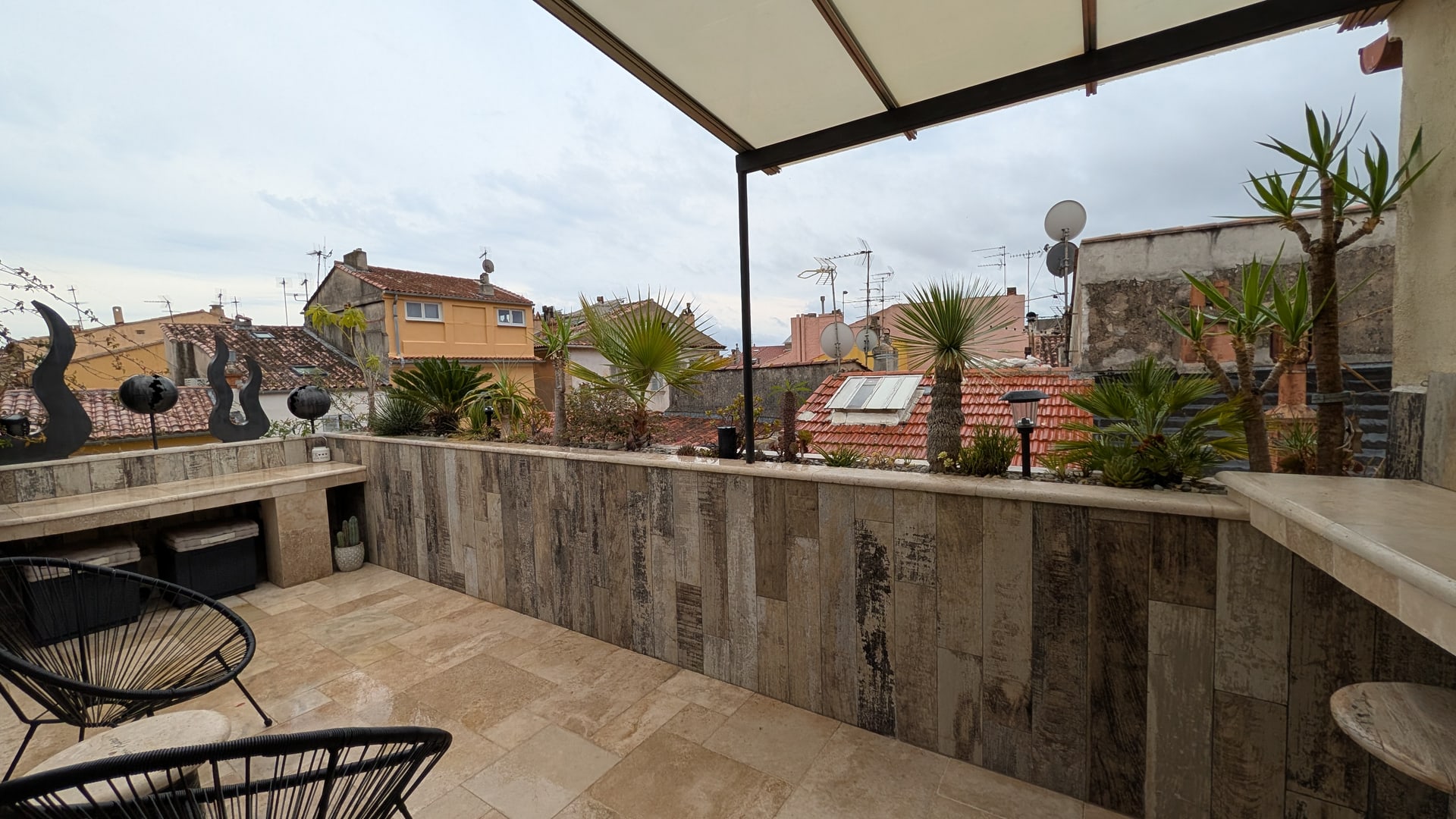 La terrasse sous sa pergola, le muret de pierre et les toits de Hyères qui s’étendent au-delà